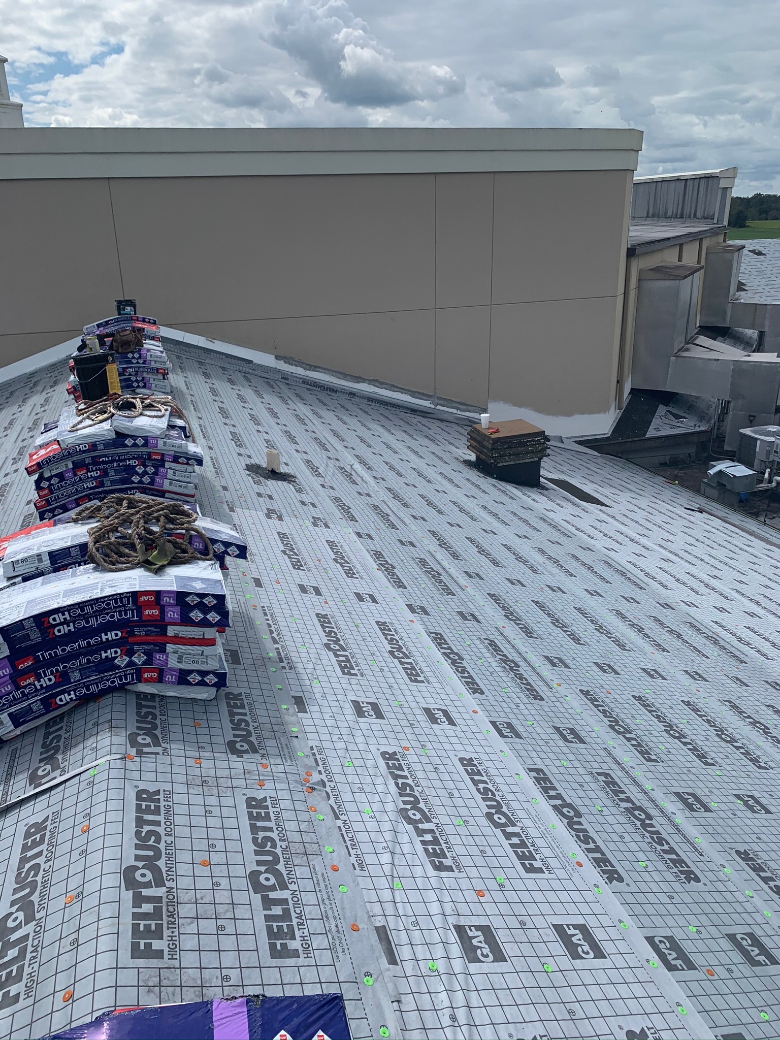 A sloped commercial roof replacement in progress by Sentinel Roofing.