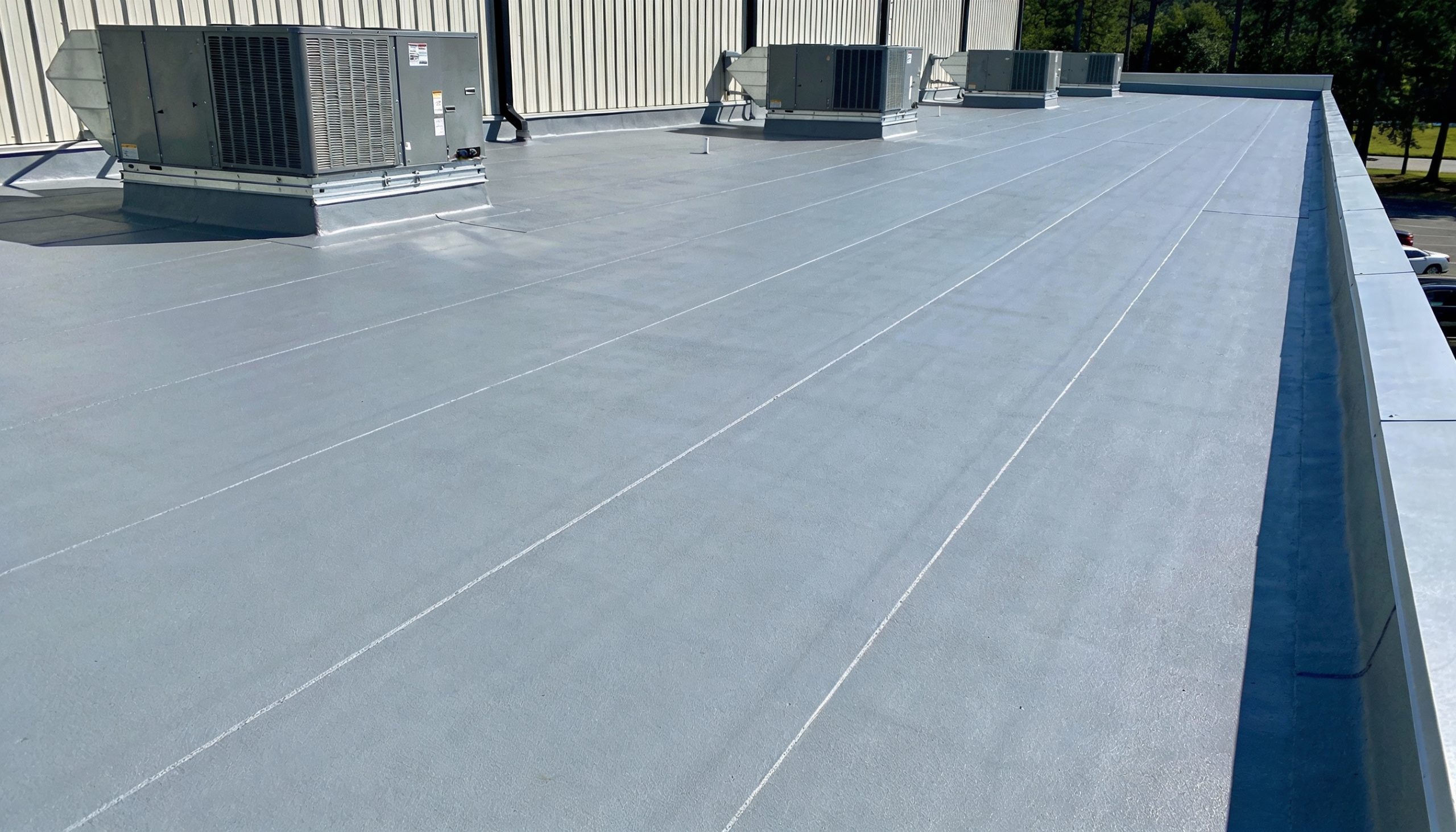 Commercial flat roofing with four rooftop HVAC units.