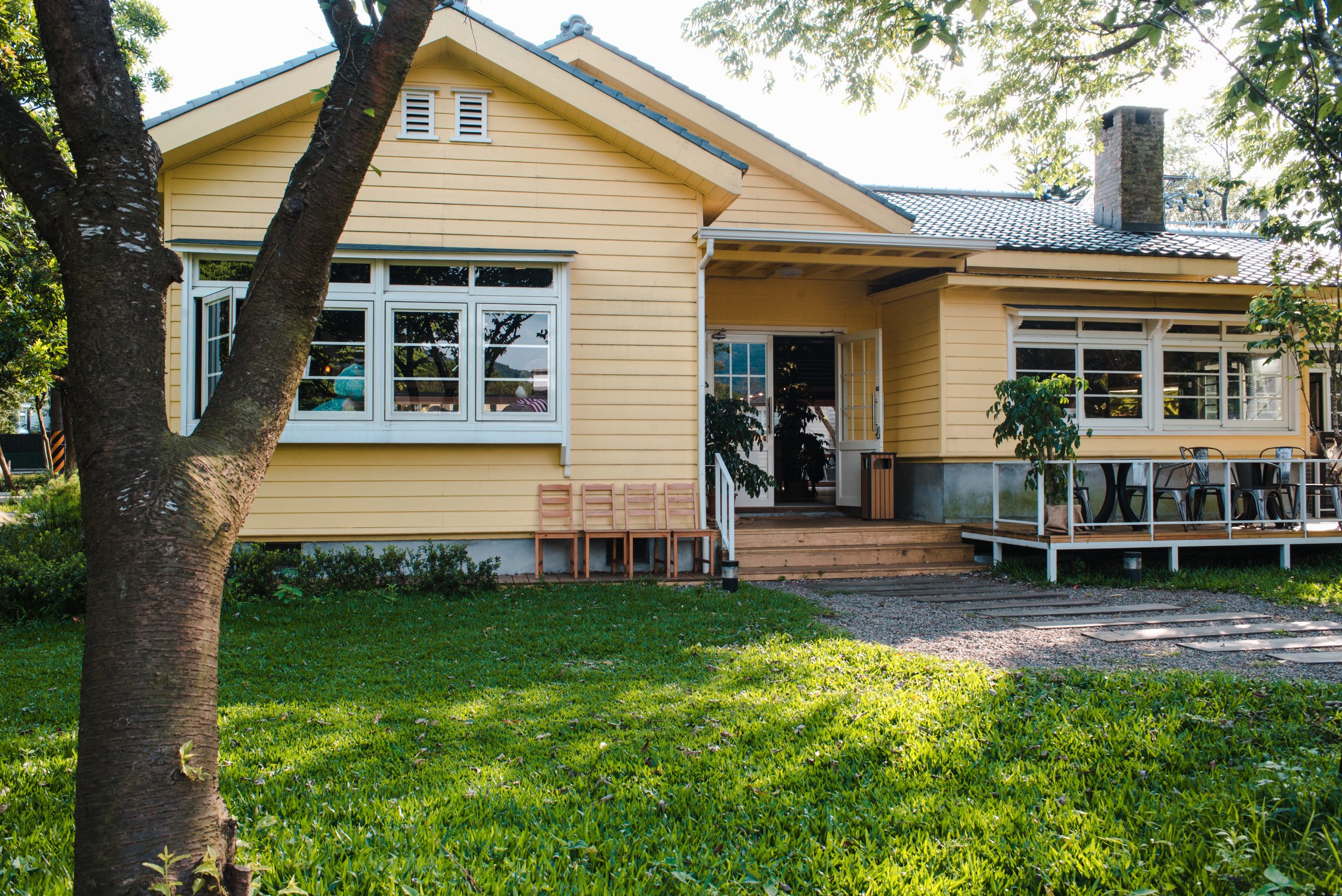 A home with yellow siding, white trim, and seamless gutters.