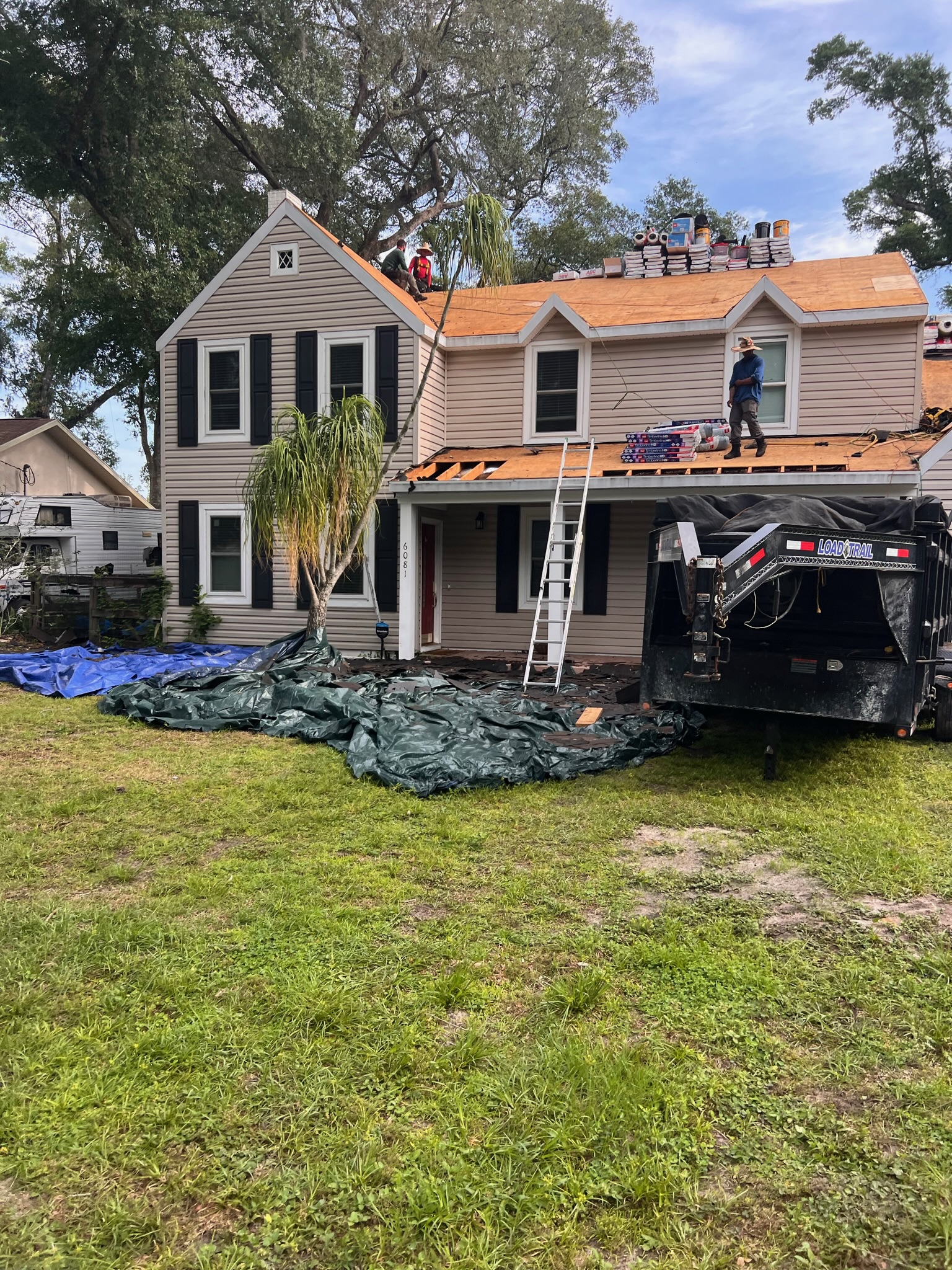 A two-story home with a roof replacement in progress.